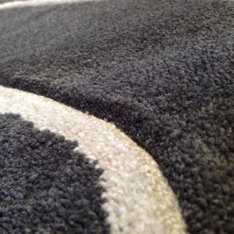 Tapis design vague avec du relief gris foncé et fines vagues en gris clair