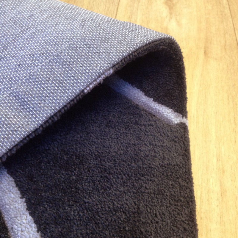 Tapis design vague avec du relief gris foncé et fines vagues en gris clair