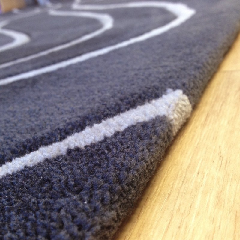 Tapis design vague avec du relief gris foncé et fines vagues en gris clair