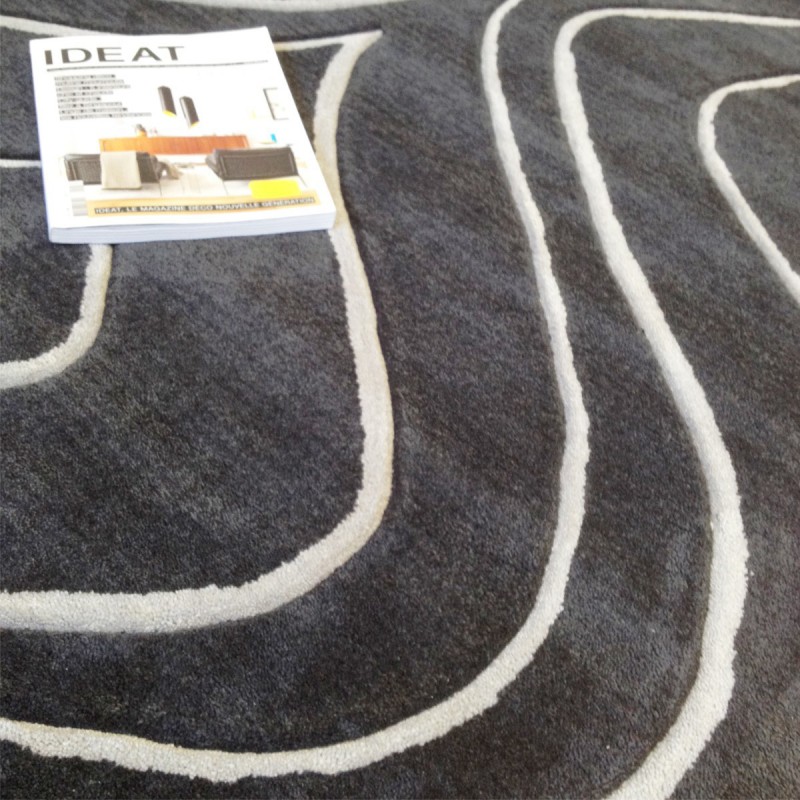 Tapis design vague avec du relief gris foncé et fines vagues en gris clair