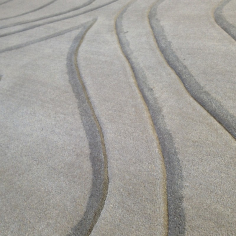 Tapis design vague avec du relief gris clair et fines vagues en gris plus foncé