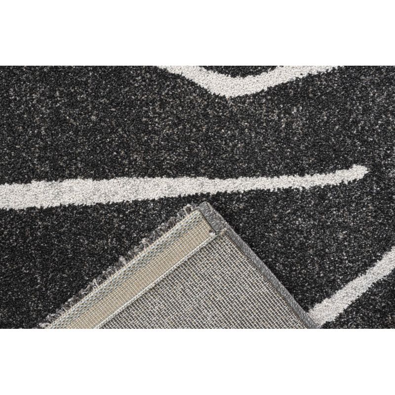 Tapis de salon polyester haut de gamme Magena design motifs blancs sur fond noir canapé table basse